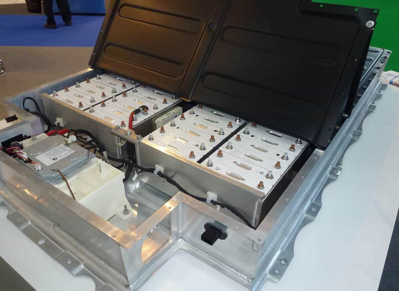 A cutaway electric car lithium-ion battery pack on display with its cover lifted to show the cell modules
