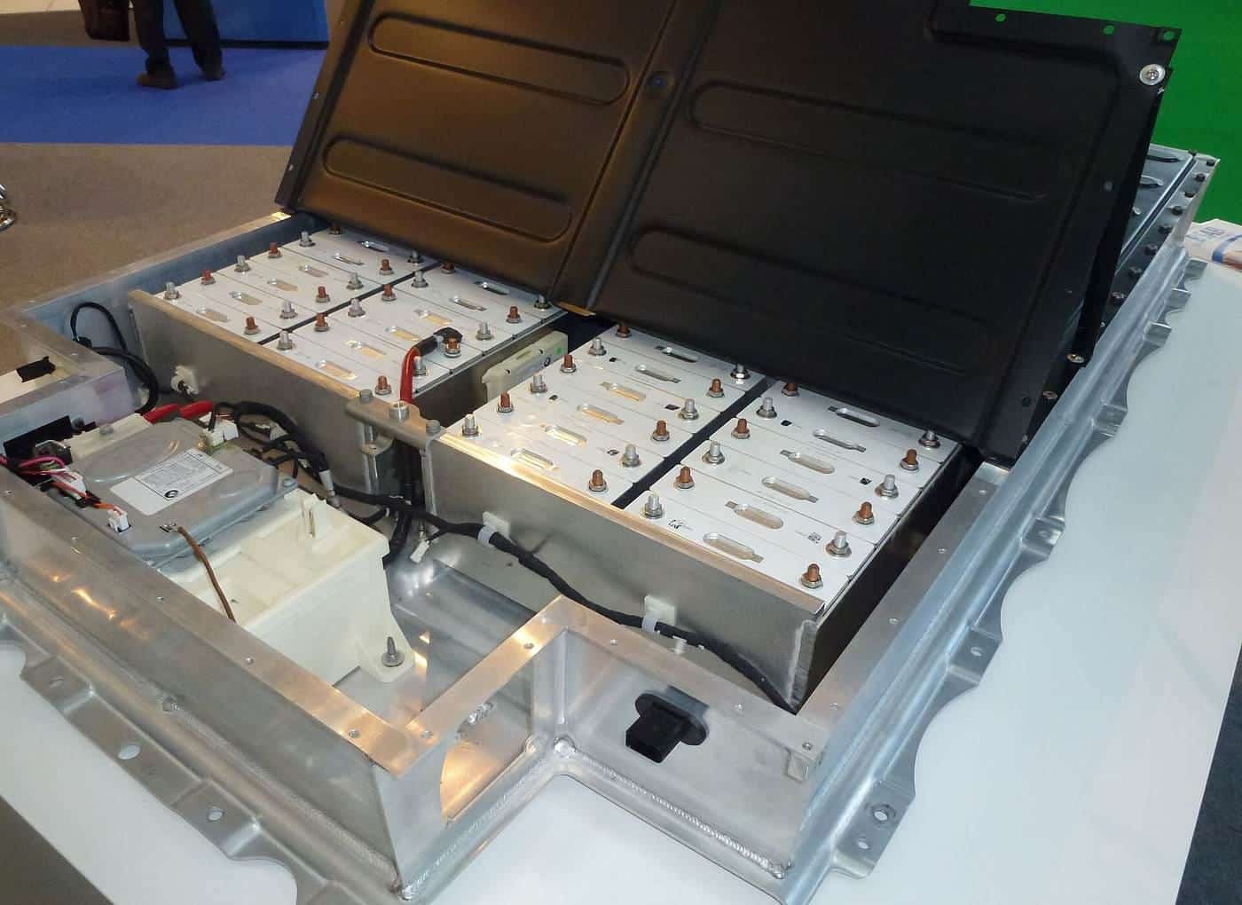 A cutaway electric car lithium-ion battery pack on display with its cover lifted to show the cell modules