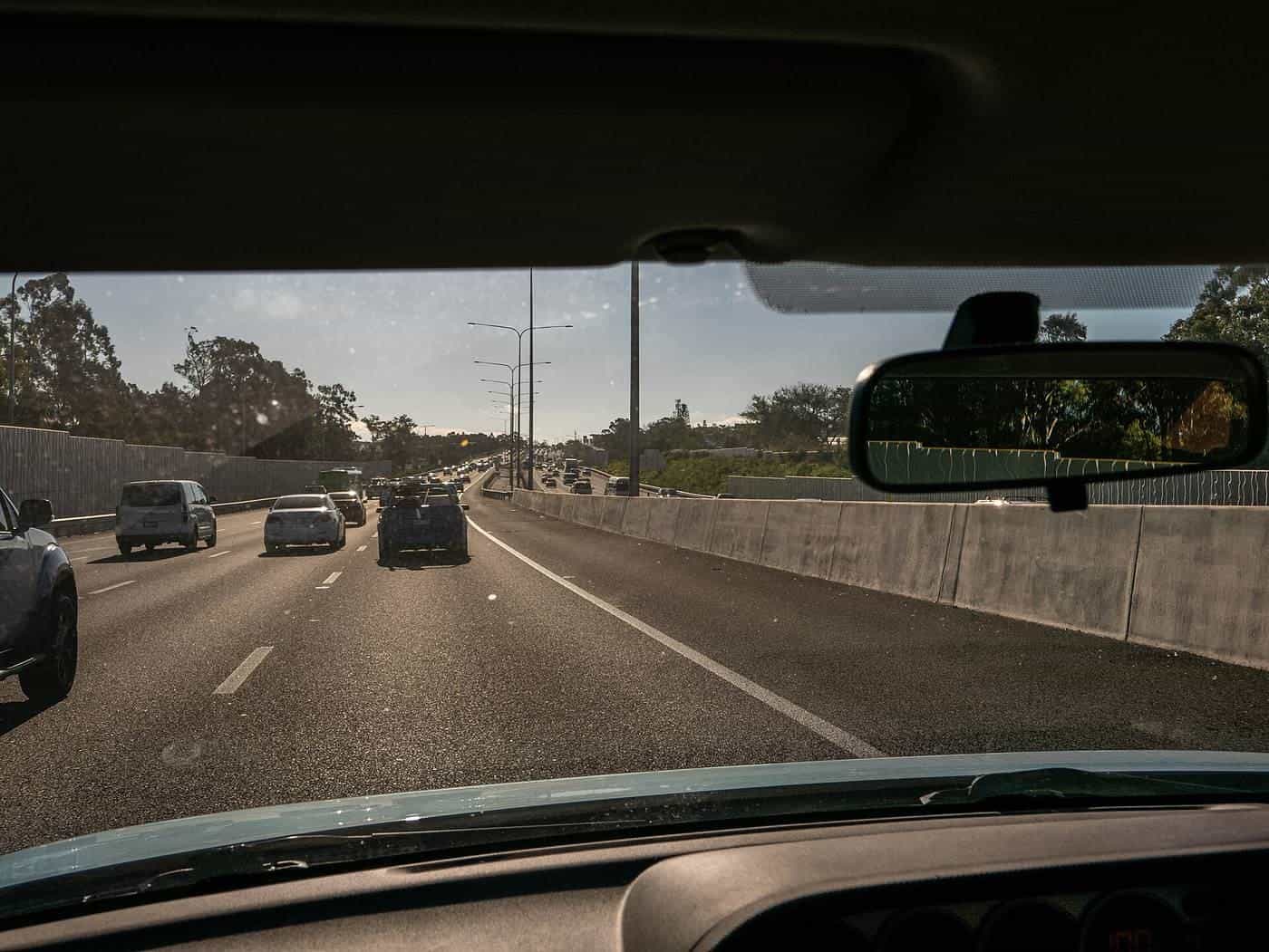 Traffic on a multi-lane highway seen through a car windscreen on an overcast day