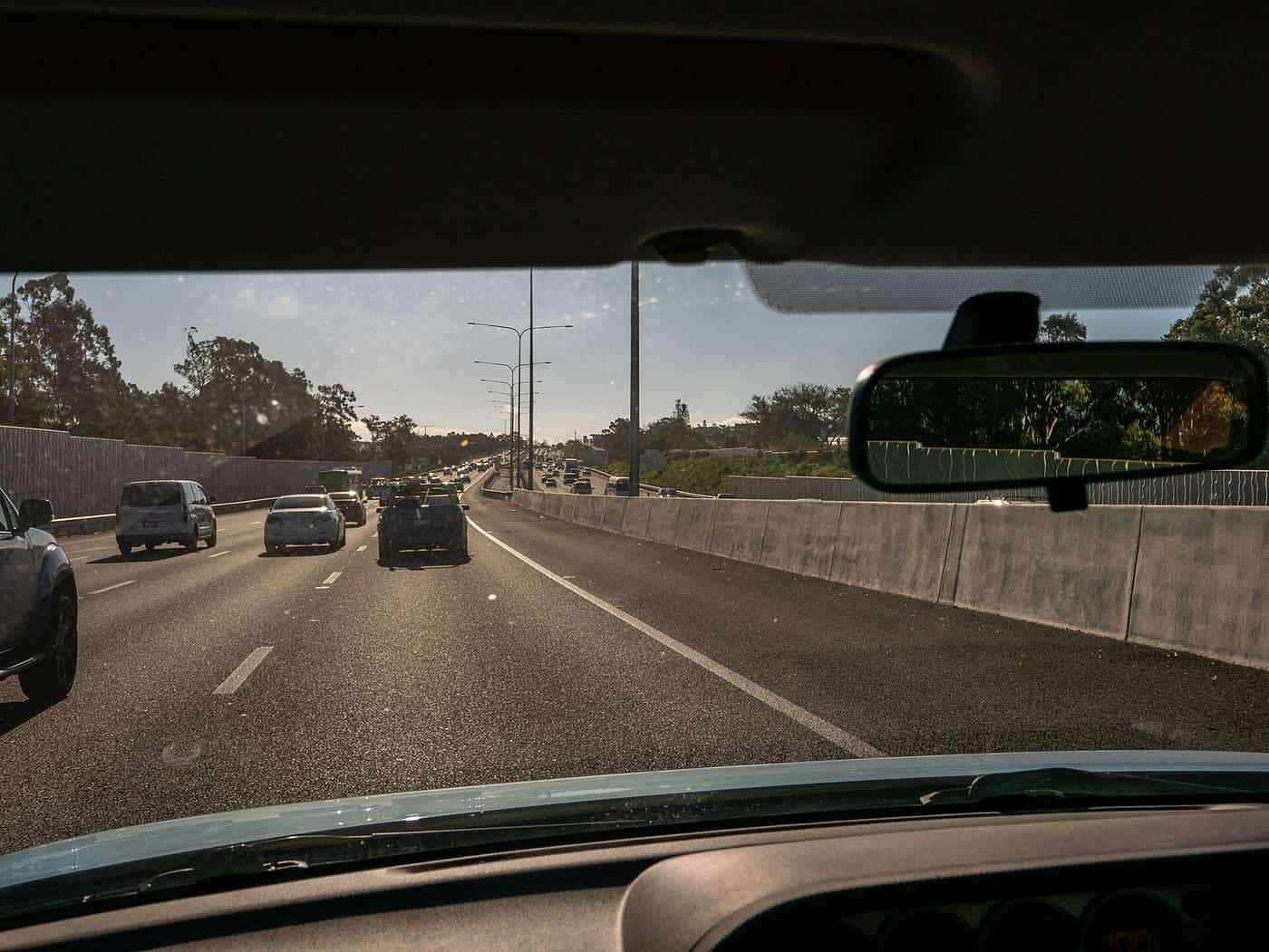 Traffic on a multi-lane highway seen through a car windscreen on an overcast day